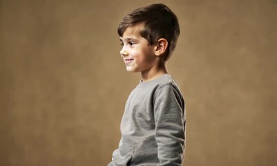 Poster - Portrait of a smiling little boy on a brown background. Studio shot.