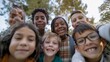 © VK Studio - A group of diverse kids stands close together, beaming with excitement and happiness, with lush greenery in the background on a sunny day.