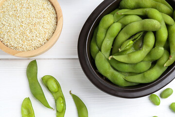 Wall Mural - Fresh edamame pods, soybeans and seeds on white wooden table, flat lay