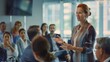 © VK Studio - A professional woman addresses an attentive audience in a modern, well-lit conference room, symbolizing leadership and corporate engagement.