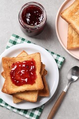 Wall Mural - Delicious toasts with jam on light table, flat lay