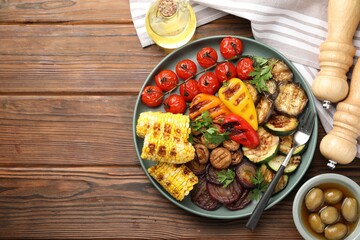 Delicious grilled vegetables served on wooden table, flat lay. Space for text