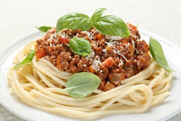 Wall Mural - Tasty pasta bolognese with basil on white table, closeup