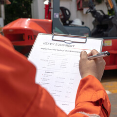 Wall Mural - a mechanical engineer is using heavy equipment checklist form for inspecting the factory forklift ve