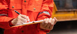 © Nattawit - Close-up at the operation supervisor is checking on heavy machine and equipment checklist form with crane truck as blurred background. Industrial safety working in action, selective focus.
