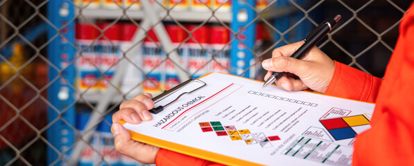 Wall Mural - extreme close-up at industrial worker'hand during verify on chemical and hazard material checklist, 