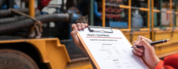 Wall Mural - action of a mechanical engineer is writing on heavy machine checklist form to verify the condition, 