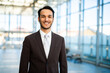 © Minerva Studio - Confident businessman smiling in modern office building