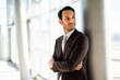 © Minerva Studio - Confident businessman leaning against column in modern office building