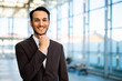 © Minerva Studio - Businessman smiling touching chin in modern office building