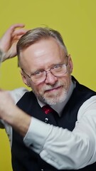 Poster - Excited mature man with dollars in hands. Happy elderly man is waving many dollar bills isolated on yellow background. Slow motion. Positive emotions. Vertical video