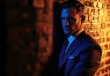 © Cetin - handsome man in a suit leaning against a wall, with a romantic atmosphere created by dark blue and red lighting