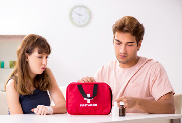 Wall Mural - Young family getting treatment with first aid kit