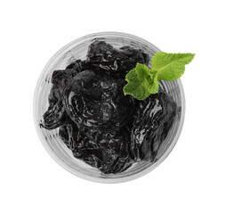 Wall Mural - Tasty dried plums (prunes) in glass bowl and mint leaves isolated on white, top view