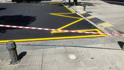 resurfacing of the road with yellow paint for parking and plastic safety tape