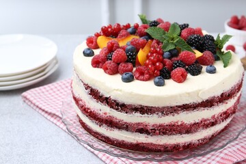 Wall Mural - Tasty sponge cake with different fruits and mint on light grey table