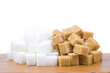 © Таня Микитюк - Sugar cubes on a wooden board, isolated on white background. Brown and white sugar.