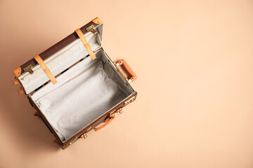 Canvas Print - Open empty suitcase on beige background, top view. Space for text