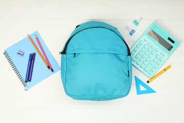 Poster - Backpack and different school supplies on white wooden background, flat lay