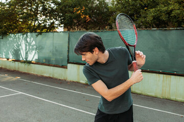 Young man preparing for a backhand hit while playing tennis. Copy space