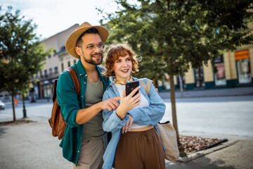 Wall Mural - Young couple, on a vacation, exploring the new city and using their phone as gps to help them not get lost.