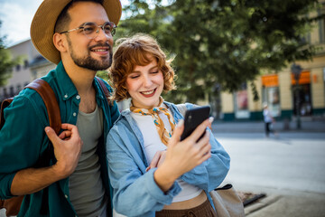 Wall Mural - Young couple, on a vacation, exploring the new city and using their phone as gps to help them not get lost.