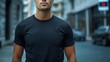 © James - Man in black t-shirt mockup, front view, blurred street background, bokeh effect, copy space for design and text.