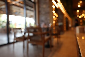 Blurred view of cafeteria with large windows and comfortable furniture