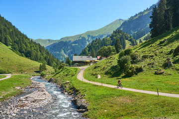 Wall Mural - active senior woman riding her electric mountain bike in the spectacular Rappenalpen Valley south of Oberstdorf in the Allgaeu High Alps, Bavaria, Germany