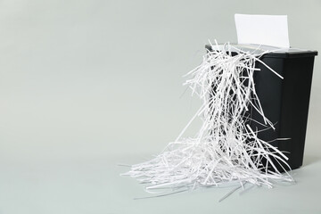 Wall Mural - Destroying sheet of paper with shredder on light grey background, space for text