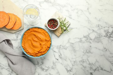 Wall Mural - Tasty mashed sweet potato in bowl, peppercorns and water with lemon on white marble table, flat lay. Space for text