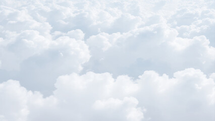 Wall Mural - White Clouds from above. Aerial view of the fluffy white cloud on blue sky. Top view from an airplane over white clouds in a blue sky. High in the Heavens.