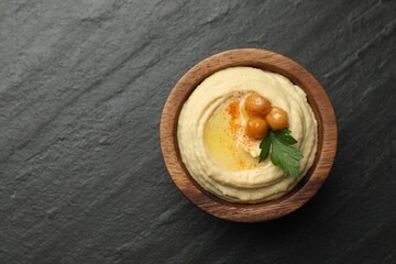 Wall Mural - Delicious hummus with olive oil, chickpeas and parsley in bowl on grey textured table, top view. Space for text