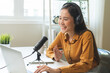 © KMPZZZ - Podcast concept asian young woman radio host work with headphones, microphone while talk, conversation and recording podcast, live on social media.Technology of on-air online in broadcasting at studio