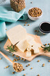 © elenarui - Organic vegetarian soy tofu and rosemary on wooden board on table vertical view