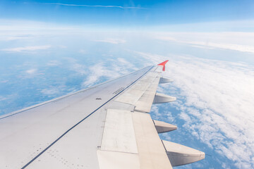 Wall Mural - View from the airplane window at a beautiful cloudy sky and the airplane wing