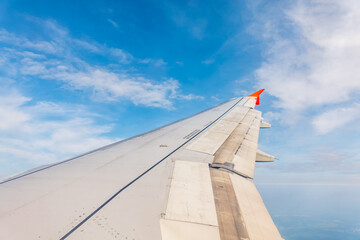 Wall Mural - View from the airplane window at a beautiful cloudy sky and the airplane wing