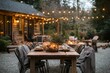 © netrun78 - Cozy outdoor dinner setup under string lights in a serene backyard during the evening