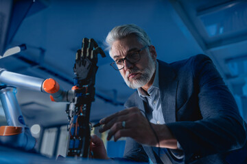 Wall Mural - Robotics engineer adjusting, calibring robotic prosthetic hand. Concept of modern technology in medicine. Robotic prosthetics, biomechatronics and neuroscience.