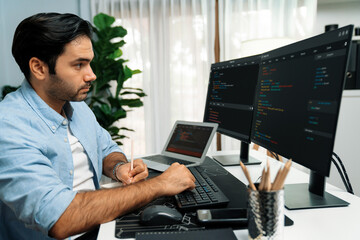 Smart IT developer writing data memo's software development on paper's coding on laptop and two pc screen, creating application program update version online website system at modern office. Surmise.