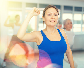 Wall Mural - Adult sports woman doing fitness in group in fitness studio