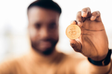 Fototapete - Digital Money Mining. Black businessman holding golden Bitcoin, symbol of new virtual currency