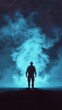 © chayantorn - A solitary figure stands in the dark, enveloped by mysterious blue smoke, evoking a sense of intrigue and adventure.