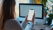 © delvin std - Portrait of a woman holding a mobile phone with a blank desktop white screen for mockup.