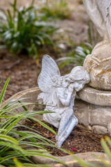 A sleeping statue of a fairy in a garden 