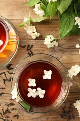 Poster - Hot jasmine tea in cups and flowers on wooden table, flat lay