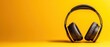 © Seksan - A sleek pair of black headphones resting on a bright yellow background, ideal for music lovers and audio enthusiasts.