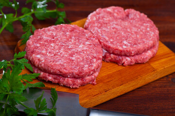 Wall Mural - Raw handmade minced pork burgers patties on wooden table