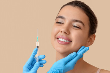 Wall Mural - Young woman receiving beauty injection on beige background, closeup