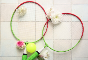 Wall Mural - Composition with tennis rackets, ball and flowers on light tile background